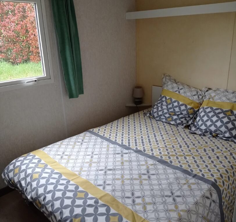 Room with one double bed in the ‘Le Laurier’ and ‘Le Palmier’ mobile homes available to rent at Le Bel Air campsite in the Lot