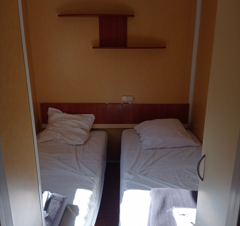 Bedroom with two single beds in the Le Figuier mobile homes