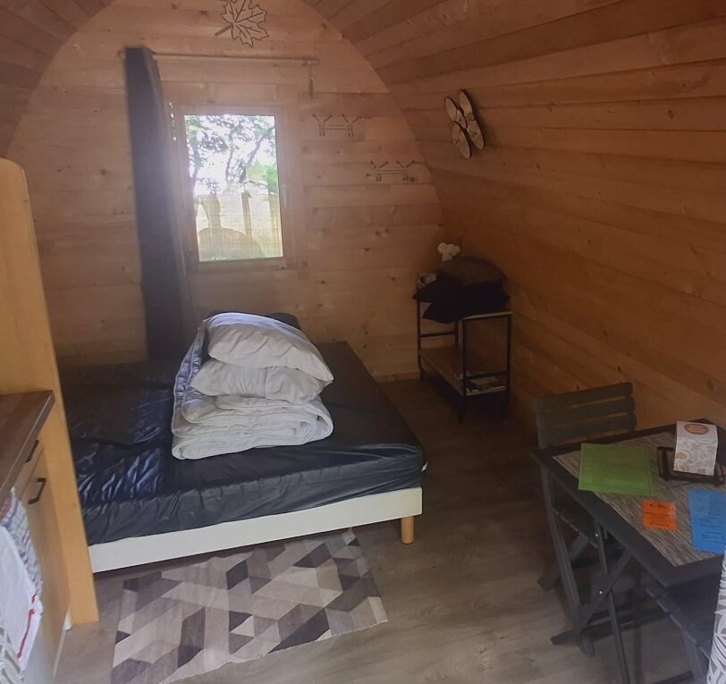 Inside the wooden pod, unique accommodation in the Lot with a double bed, available to rent at Le Bel Air campsite in the Lot